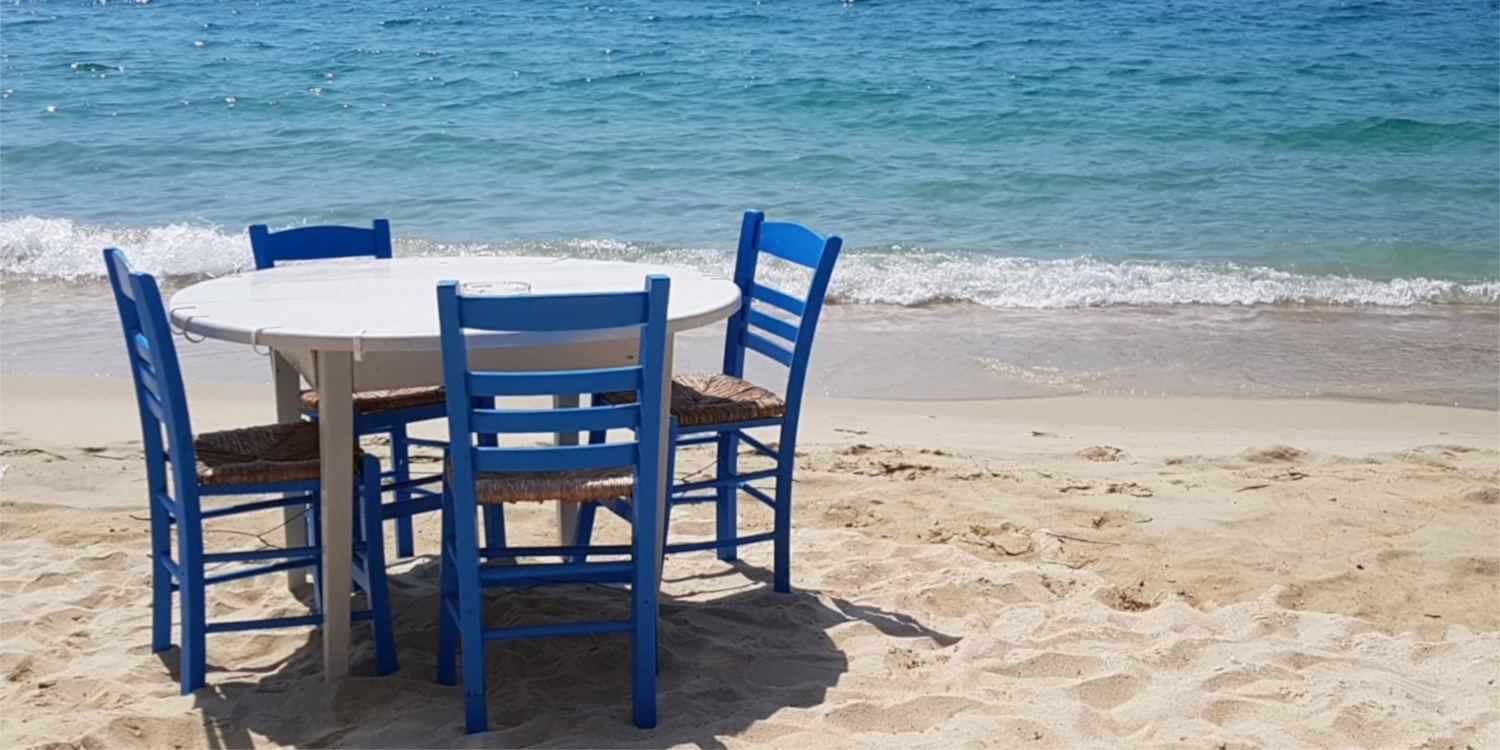 Vier Stühle stehen vor dem unendlichen Meer